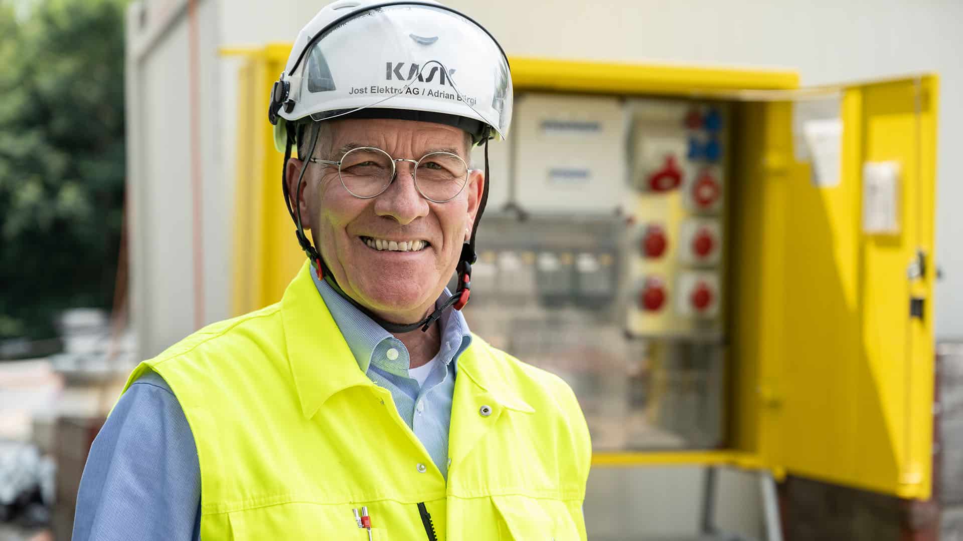 Adrian Bürgi, Jost Elektro AG, mit Bauhelm vor provisorischer Stromverteilung auf Baustelle KSB-Neubau