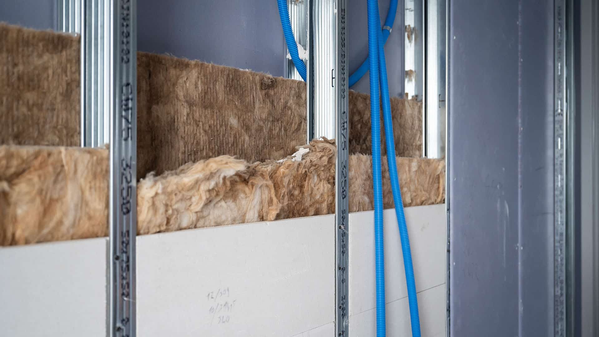 Isolationsmaterial und blaue Rohre in Wand im KSB-Neubau